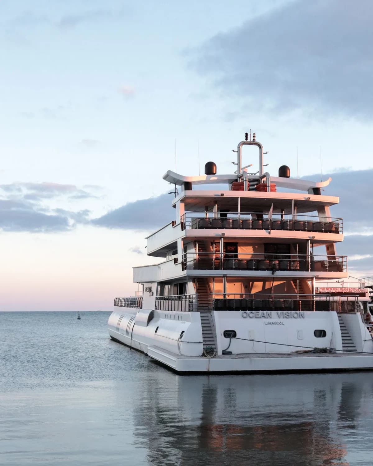 A motor yacht moored in a harbour at sunset